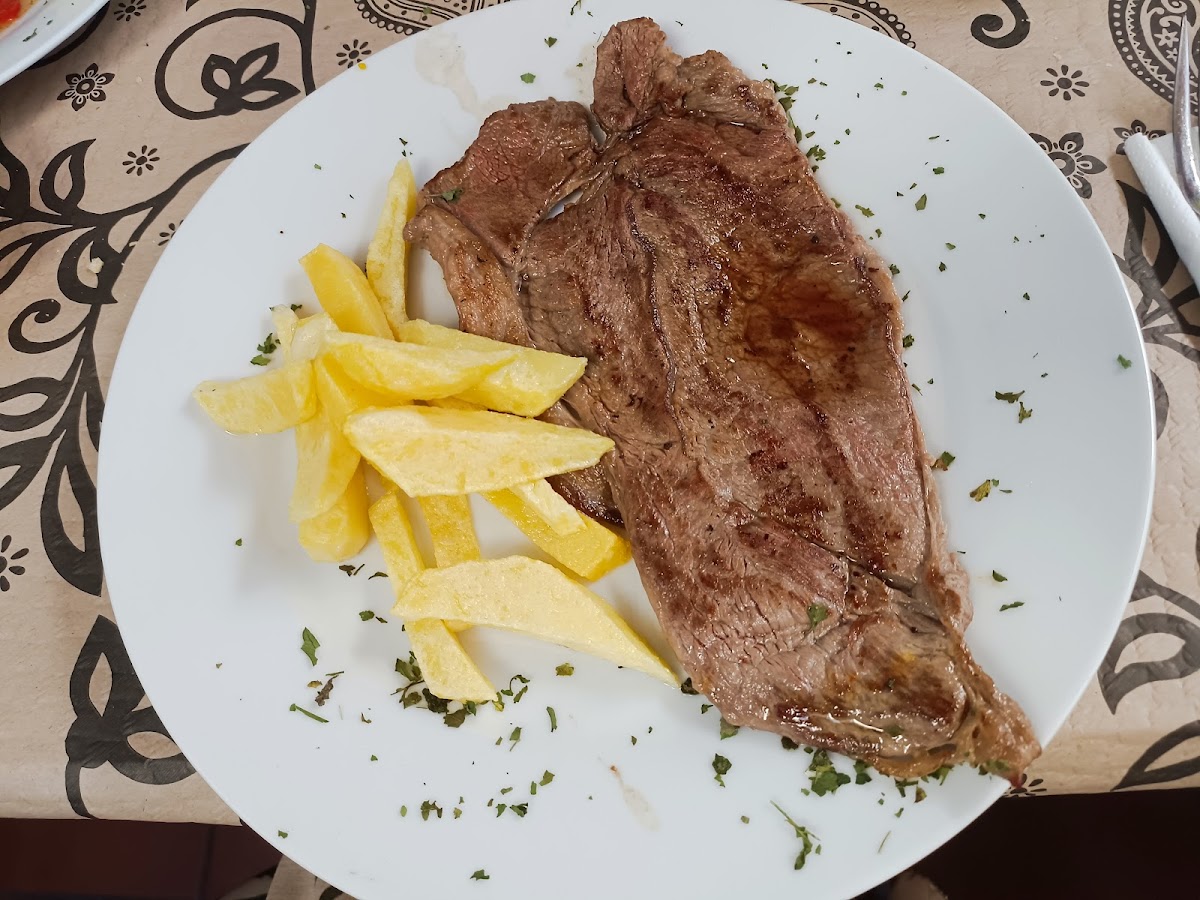 Plato de bistec jugoso con patatas fritas